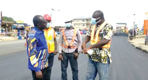  Mr Darko-Quarm (left), Gomoa East DCE, interacting with workers on the Gomoa Nyanyano road
