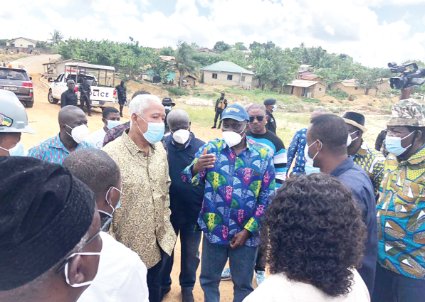 Nana Otuo Siriboe II (arrowed), the Chairman of the Council of State, interacting with Mr K. Bonzoh (right), the District Chief Executive of Ellembelle, at one of the  galamsey sites. With them are Mr Kwabena Okyere Darko-Mensah, the Western Regional Minister, and other members of the Council