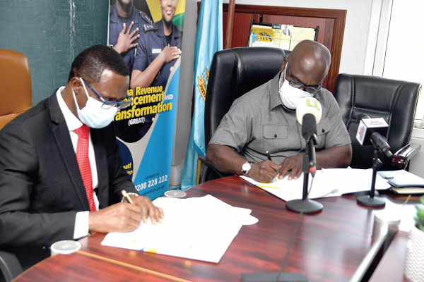 Mr Ammishaddai Owusu-Amoah (left), Commissioner–General of the Ghana Revenue Authority, and Mr Peter Mireku, Chief Executive Officer of the Gaming Commission, signing the agreement on behalf of their repective organisations. Picture: EMMANUEL QUAYE