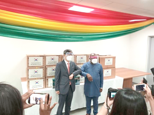 Mr Ham Sang-wook (left), Deputy Minister for Multilateral and Global Affairs of the Republic of Korea, presenting the items to Mr Agyeman-Manu, Minister of Health