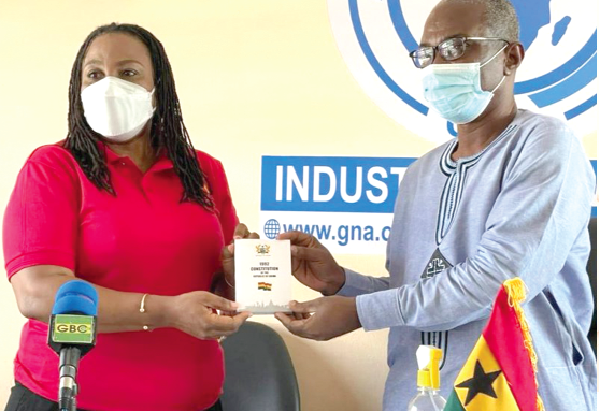 Ms Josephine Nkrumah, the Chairperson of the NCCE (left), presenting a copy of the 1992 Constitution to Mr Francis Ameyibor, the Tema Regional Manager of the Ghana News Agency