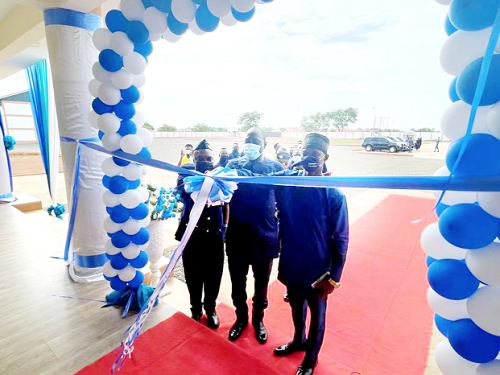 Col (Retd) Kwadwo Damoah (middle), Commissioner of the Customs Division of GRA, being assisted by Assistant Commissioner of Customs Raphael Owurani-Bediako (right), the Tamale Sector Commander and Mr Osman (left), the Managing Director of Savanna Works Limited, to cut the ribbon to inaugurate the state warehouse and new block of offices