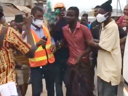 Benjamin Kofi Yeboah being held by neighbours