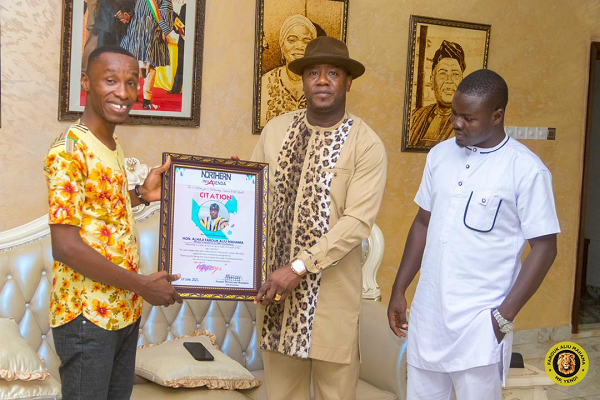 Mr Alexander Jimpetey ( left) , CEO for Northern Youth Agenda presenting the citation to Alhaji  Farouk Aliu Mahama (middle ) MP for Yendi