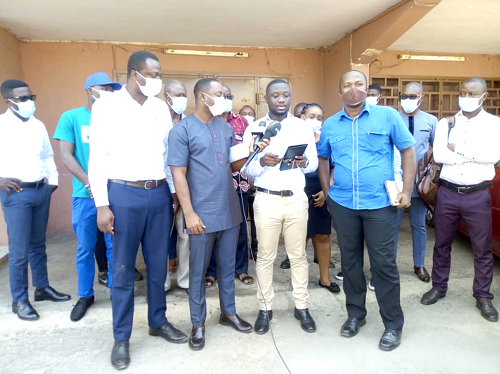 Mr Michael Kwablah (middle), Coordinator, Concerned Shareholders of First Fund, addressing the media. Behind him are some of the aggrieved shareholders