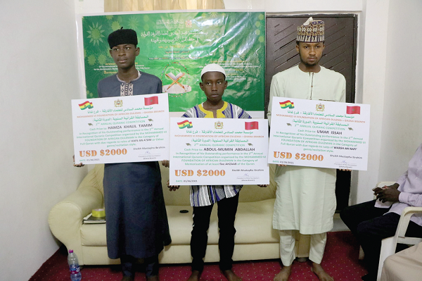 •  Hamza Khalil Tamim (left), Abdul-Mumin Abdullah (middle) and Umar Issah displaying their dummy cheques