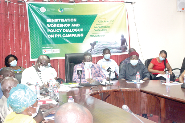 Mr Seth Osei-Akoto (middle), Director of Crop Services at MoFA; Dr Charles Kwowe Nyaaba (2nd right), Head of Programmes and Advocacy of the Peasant Farmers Association of Ghana (PFAG), deliberating on  the findings of the report. With him are  some members of the association