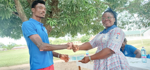 Madam Lois Tipong-Asare presenting a cheque for Gh¢5,000 to Mr Emmanuel Dzila, a beneficiary