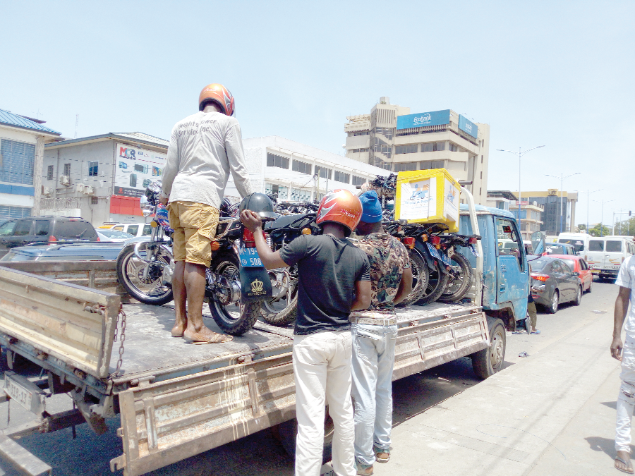 Some impounded motorbikes being loaded onto a truck