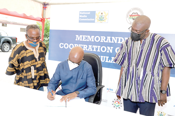  Mr Joe Anokye (middle), Director-General of the NCA, signing the document in Accra. Looking on are Mr Kojo Oppong Nkrumah (right),  Minister of Information, and Mr Yaw Boadu-Ayeboafoh (left), Chairman of the NMC. Picture: GABRIEL AHIABOR