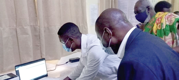 Dr Patrick Kuma-Aboagye (right), Director-General of the GHS, being taken through the testing process
