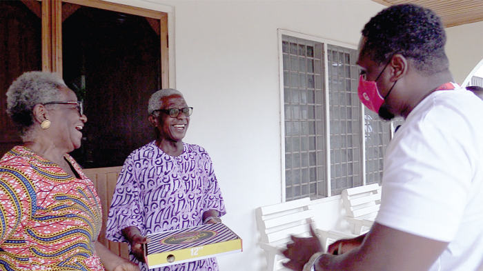 Dr Wurapa smiling as he receives the surprise package from Mr Kwabena Berko, Events Manager, GCGL