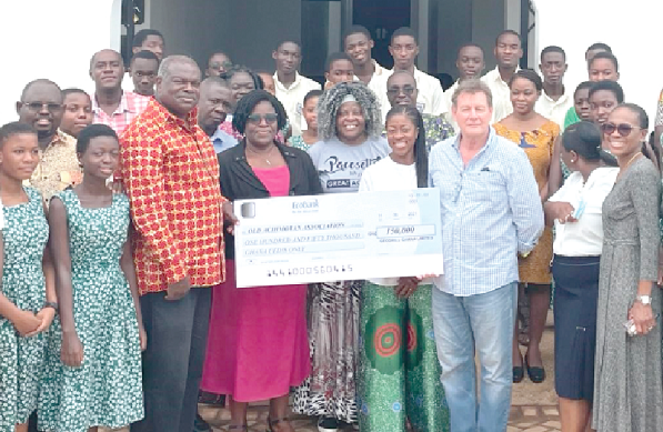 • Professor Ernest Aryeetey (3rd left), President of the OAA, receiving the cheque from Mr David Harper, CEO of Geodrill, while some staff and students look on