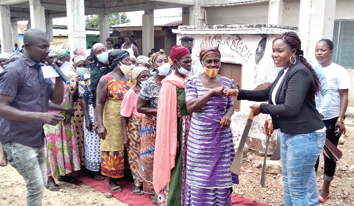Ms Appoh (right) distributing machetes to some widows during the exercise