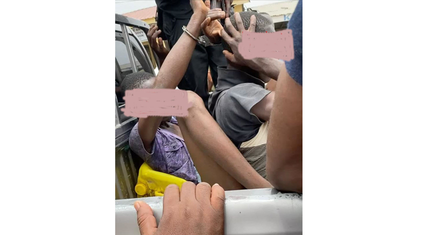 The suspects in police grip being transported to the police station