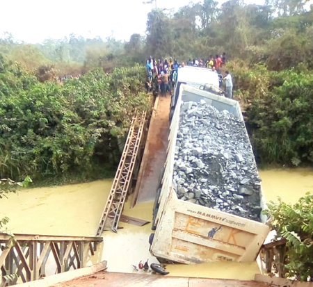 The heavy-duty truck which caused the accident stuck on the collapsed steel bridge on River Mamie 