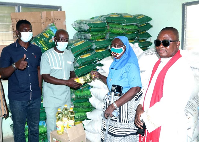 Mr. Thaddeus Sory makes a symbolic presentation of the gift items to the leadership of the widows association 