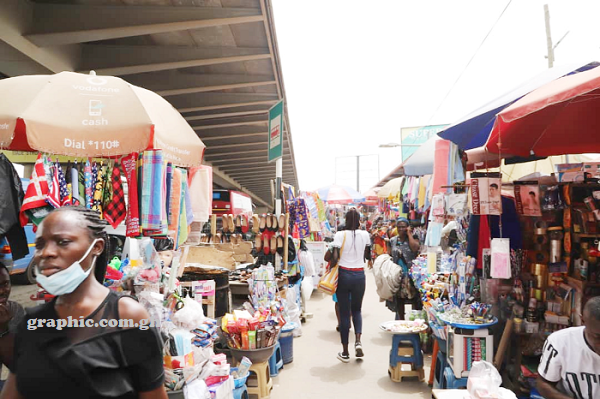 A full market session on a pavement under a part of the Kwame Nkrumah Circle Interchange
