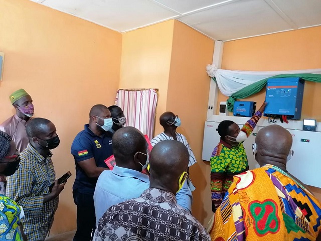 Mr. Andrew Etwire (hands up), the contractor for the power project explaining how the system works to the entourage from the community and the school’s teaching and non-teaching staff. With them are Nana Kofi Yankom IV, Chief of Pretea, the headmaster, Messrs Yankey and Adatekey in (Smock).