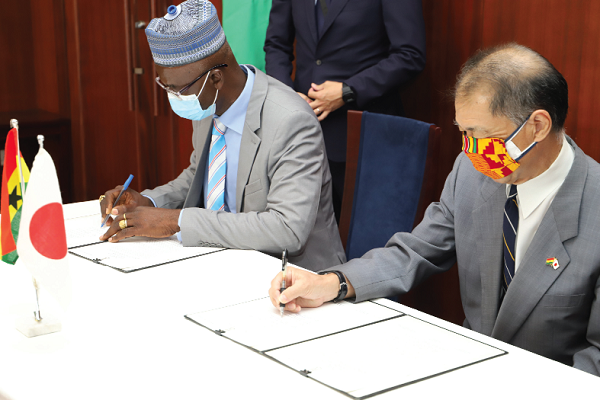 Mr Himeno Tsutomu (right), the Japanese Ambassador to Ghana, signing the agreement with Mr Thaddeus Zaasan (left), the Municipal Coordinating Director of the Kintampo Municipal Assembly. Picture: GABRIEL AHIABOR