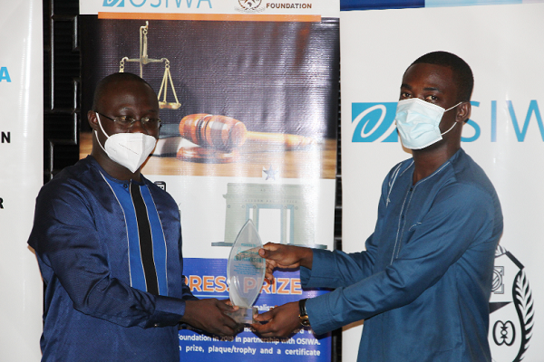 Mr Ebo Hawkson (right), a journalist, receiving his plaque from Mr Dennis Armah, the President of African Heights Foundation 