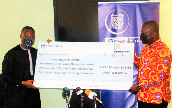 Mr. Alfred Baku (left), the Executive Vice-President and Head of Gold Fields West Africa, presenting a dummy cheque for GH¢120.7 million to Mr. Samuel Jinapor, Minister of Lands and Natural Resources