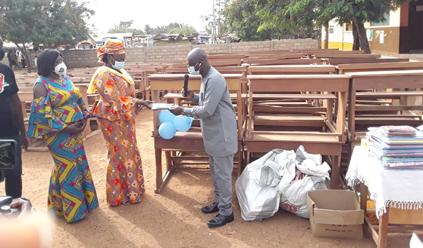 Prof Kwasi Opoku-Amankwa (right), DG of the GES, handing over some of the learning materials to Madam Janet Tulasi Mensah (middle), the Ga East MCE, while Ms Faustina Alimah Braimah, Ga East Municipal Education Director looks on