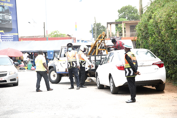 A vehicle parked at the way side being prepared  to be towed while DSP Francis Aboagye and his men look on. Picture: EBOW HANSON