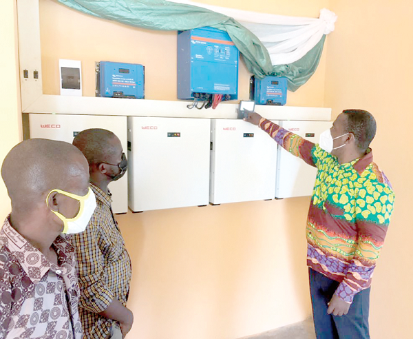 Mr Andrew Etwire (right), the contractor for the power project, explaining the system to Mr Benjamin Yankey, headteacher of the M/A Basic School