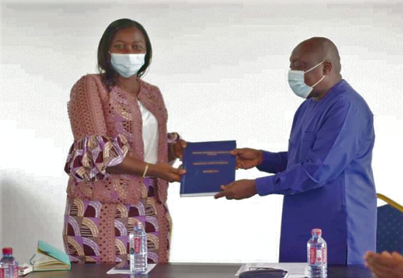 Mr Kingsley Adjei Boahen (right), the Regional Coordinating Director, presenting the handing over note to Mrs Justina Marigold Assan, the Regional Minister