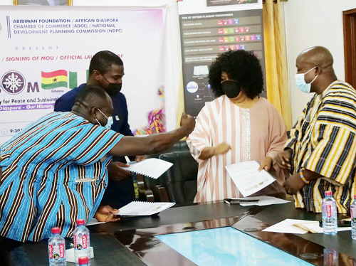 Mr Kwabena Okai Ofosuhene (left) of the Abibiman Foundation, Mr Felix Addo-Yobo (2nd left), NDPC, Ms Pat MacCant (2nd right) of the ADCC, and Mr Charles Yomekpe (right), CEO of Abibiman Foundation, exchanging pleasantries after the signing formalities.  Picture: EBOW HANSON