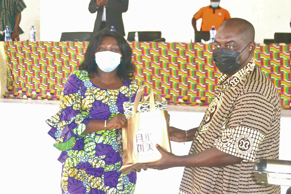 Dr Isaac Bampoe-Addo (right), Executive Secretary of CLOGSAG, presenting a parcel to Mrs Justina Marigold Assan, Central Regional Minister