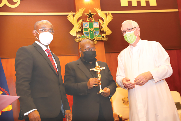 President Akufo-Addo holding a gift presented to him by Rev Fr. Andrew Campbell, Parish Priest, Christ the King Parish, during the meeting. With them is Mr Kingsford Arthur (left), Chairman of the  Pastoral Council of the Christ the King Church. Picture: SAMUEL TEI ADANO