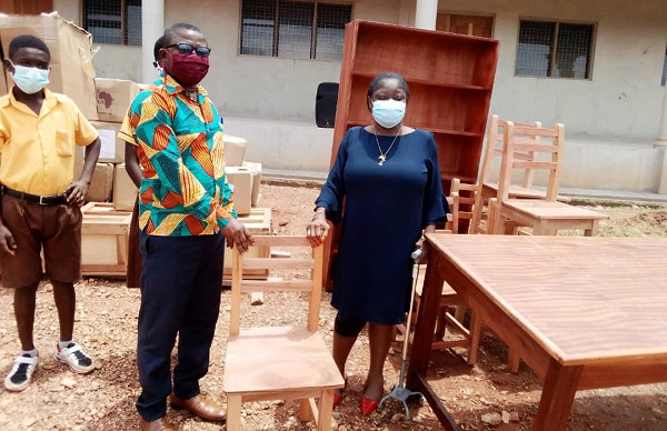 The Headmaster of the D/A JHS, Manso Adubia, Seth Amissah (Left) receiving the library items from the Director of the Ghana Book Trust, Madam Genevieve Eba-Polley.