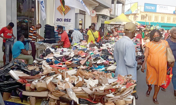 Some shoe sellers displaying their wares on trucks on the pavement