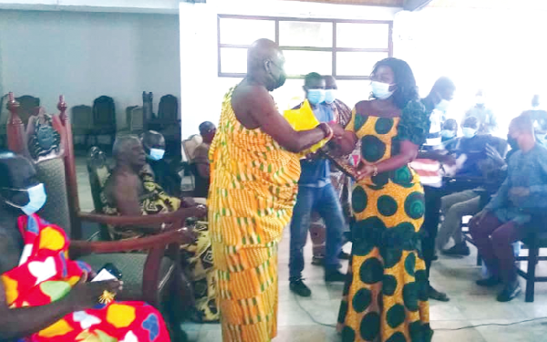 Osabarima Kwesi Atta II, Omanhen of Oguaa Traditional Area, making a presentation to Mrs Justina Marigold Assan, the Regional Minister