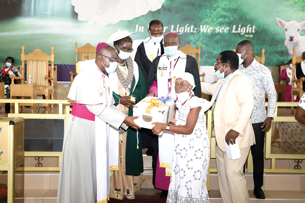 Ms Aku Allotey (2nd right), 91, a member of the Methodist Church, presenting  the 100-year old Bible to Rt. Rev. Michael Bossman (left), Administrative Bishop of the Church at a ceremony in Accra. Looking on are Rt. Rev. Samuel Kofi Osabutey (middle), Bishop of the Accra Diocese of the Methodist Church, and other ministers of the gospel. Picture: GABRIEL AHIABOR