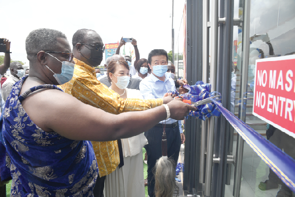 Mr Alan Kyerematen (2nd left), the Minister of Trade and Industry,  being assisted by Mrs Yang Yang (3rd left), the CEO of Zonda Tec Ghana,  and some invited guests to cut a tape to officially open the new Dzorwulu office of Zonda Tec Ghana