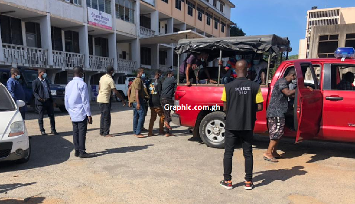 The accused persons being led from the court into a waiting police vehicle 