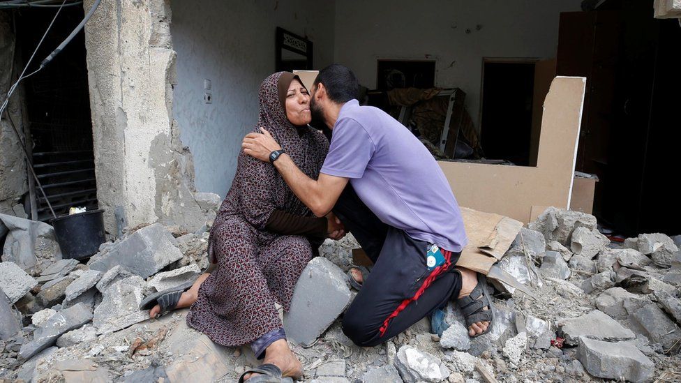 image captionA mother and son embrace in their ruined home in Beit Hanoun, Gaza
