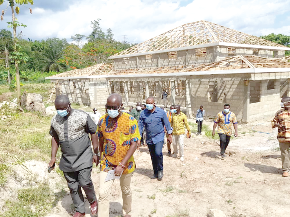 Mr Alexander Frimpong (left), District Chief Executive for Asante Akim, with Nii Lantey Vanderpuiye after inspecting work on a court complex in the municipality