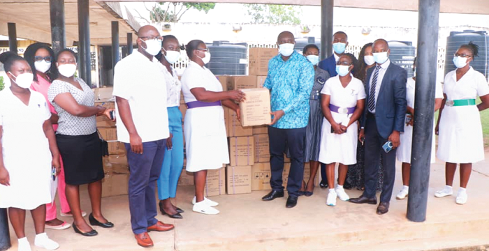 Mr Frederick Amissah (4th right), CEO, Universal Hospitals Group, presenting  one of the donated items to Ms Lena Anane Abebrese, Senior Medical Officer, Pantang Psychiatric Hospital. Looking on are staff of the UHG and Pantang Psychiatric Hospital