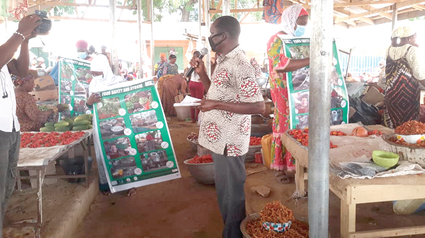 Mr Francis Yelyen educating market women and consumers  on food safety and hygiene
