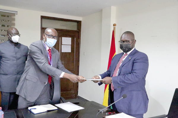 • Dr John Amaglo (middle), President, Ghana Institution of Surveyors, presenting the ‘GHiS at a Glance’ book to Mr Francis Asenso-Boakye (right), the Minister for Works and Housing