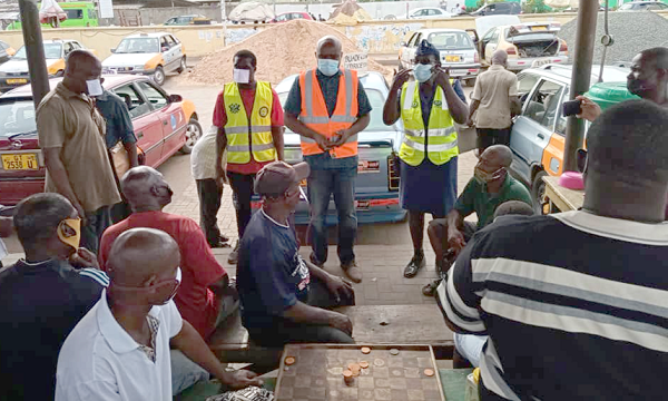 Mr Joshua Nii Bortey (arrowed), MCE, KroMA, looks on as DSP Stella Ewool (standing left), Kpeshie MTTD Commander, engages some drivers on safe driving tips