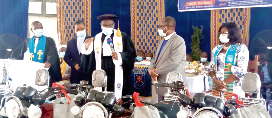 Rt Rev. Obiri Yeboah Mante (3rd left) speaking after presenting the motorbikes to Rev. Alex Owusu-Addo (left), the Presbytery Chairperson. Those with them are Ms Stella Amofaa Dodoo and other ministers