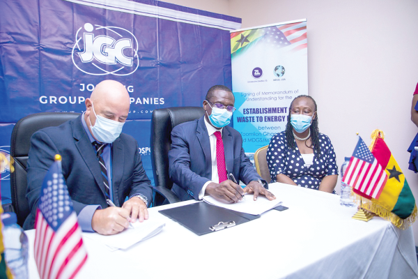 Mark Boswell (left), President, MDGS/MD Power, and Dr Siaw-Agyepong (2nd left) signing for their respective companies. Looking on is Madam Gloria Anti, Managing Director of Zoomlion 