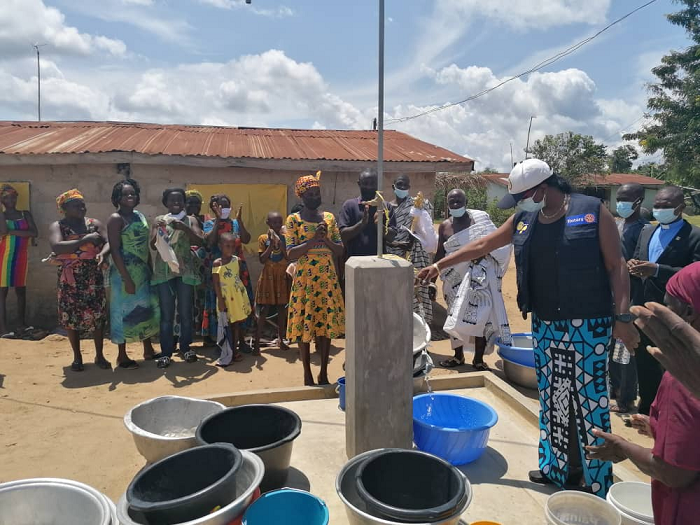 The District Governor (DG) of the Rotary District 9102, Madam Yvonne Kumoji (in cup) fetching water from one of the five stand pipes during the inauguration of the Dokrochiwa groundwater based piped water supply system