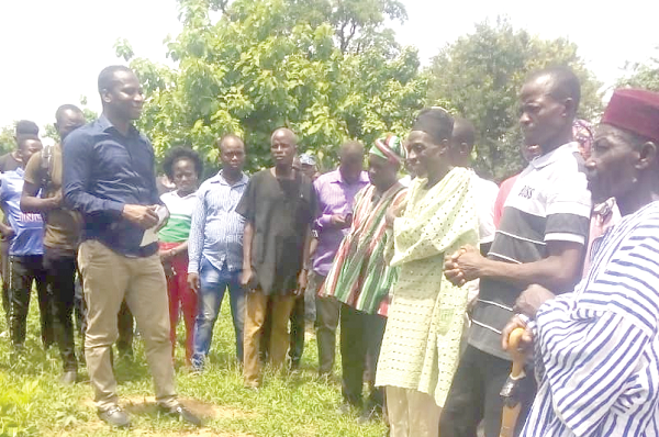 Mr John Oti Bless (left), MP for Nkwanta North, addressing some residents after the sod-cutting