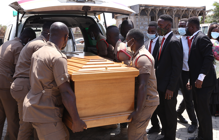 The coffin containing the remains of Albert Sam being placed in the hearse